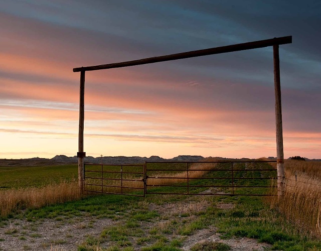 Pink and blue sunset over a ranch gate